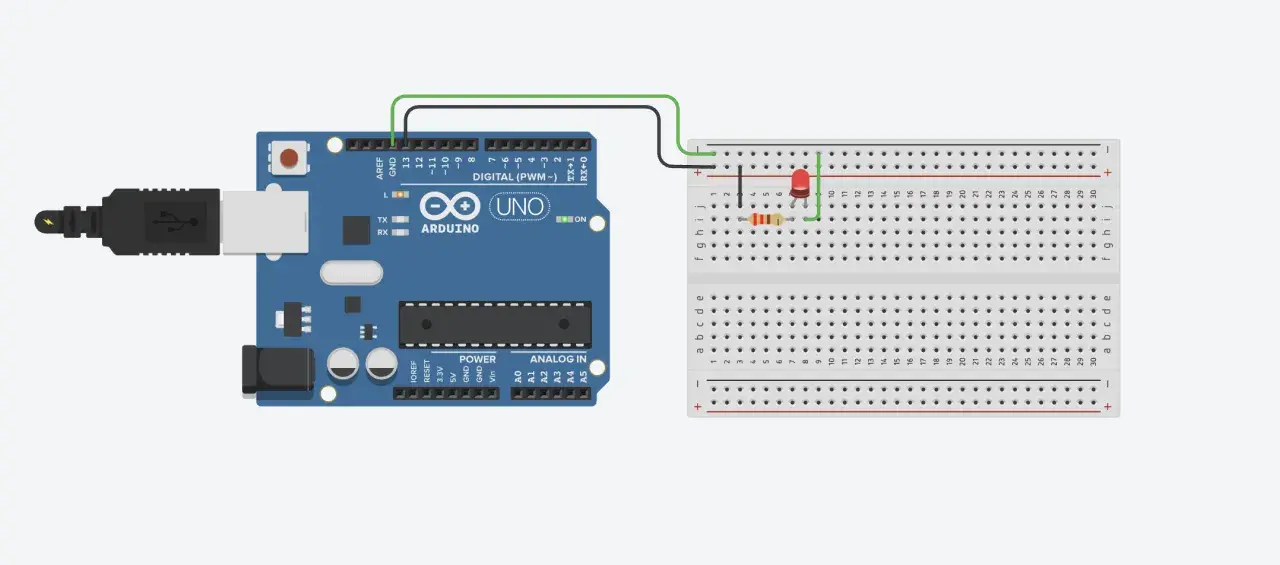 Un Arduino UNO collegato via USB a un computer, con un LED e un resistore connessi a una breadboard cos'è, per creare un circuito semplice.