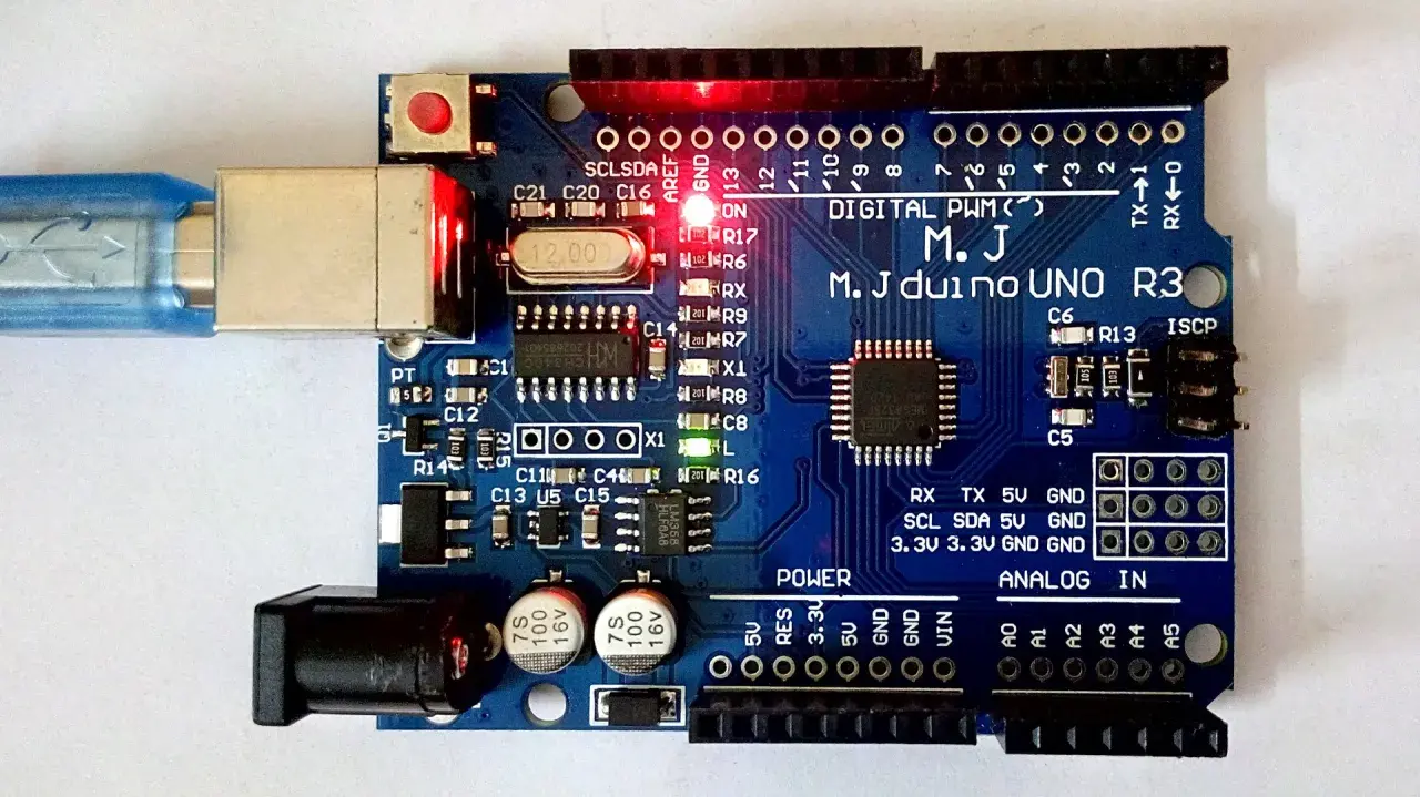 Microcontrollore Arduino UNO R3 con cavo USB collegato e LED accesi. Pronto per progetti di elettronica.