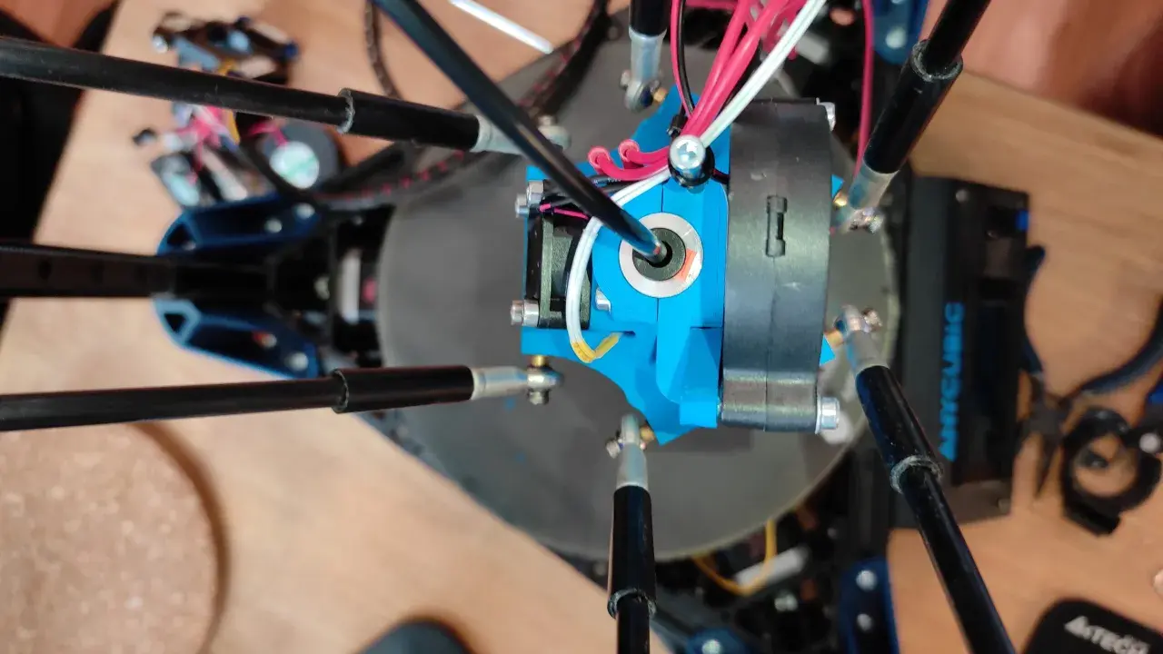 Parti di una Anycubic Kossel Linear Plus, con cavi rossi e bianchi che si snodano attorno all'estrusore blu.