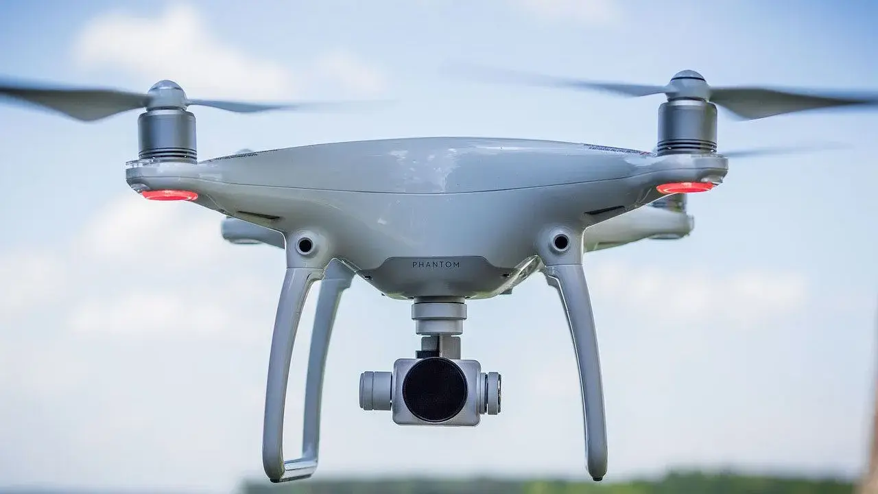 Un drone bianco con quattro eliche in movimento, pronto a catturare immagini aeree.