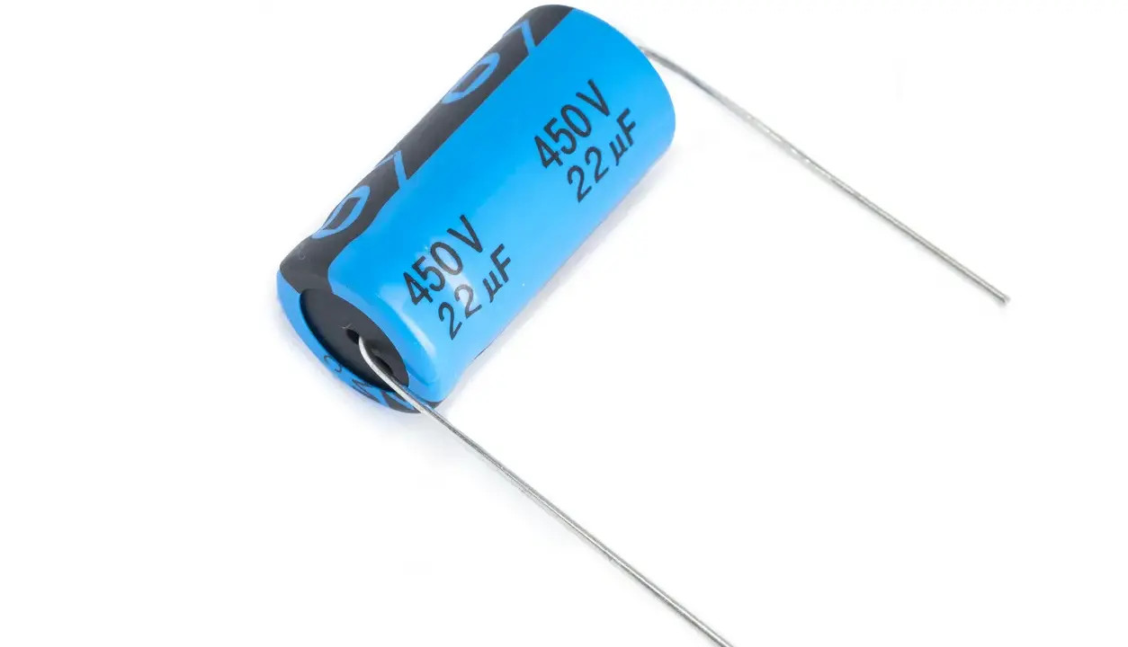 Un condensatore polarizzato blu con specifiche 450V 22µF, pronto per essere saldato.