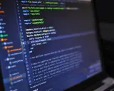 Codice sorgente su schermo scuro, con evidenziate righe di Ruby per il **front end**.