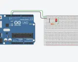 Un Arduino UNO collegato via USB a un computer, con un LED e un resistore connessi a una breadboard cos'è, per creare un circuito semplice.