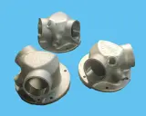 Tre componenti metallici complessi, realizzati con stampa 3D acciaio, mostrano un design intricato con diverse aperture e un logo inciso.