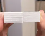 Due campioni stampati in 3D, uno con evidenti linee orizzontali dovute a z wobble, l'altro liscio.