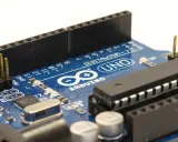 Primo piano di una scheda Arduino Uno, con il nome "ARDUINO" ben visibile. Ideale per progetti di elettronica.