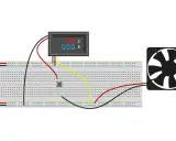 Schema collegamento voltmetro amperometro per ventola. Due alimentatori, un pulsante, un voltmetro/amperometro digitale e una ventola collegati su breadboard.