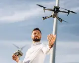 Uomo con telecomando e drone in volo, pronto per il suo patentino drone Lussemburgo.
