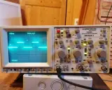 Un oscilloscopio Hamg HM 1004-3 mostra un segnale a onda quadra, probabilmente generato da un Arduino, con impostazioni di tempo e voltaggio visibili.