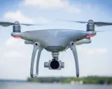 Un drone bianco con quattro eliche in movimento, pronto a catturare immagini aeree.
