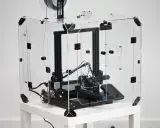 Stampante 3D Ender 3 in teca trasparente, pronta per aggiornamenti firmware.