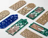 Segnalibri in legno e acrilico con intricati **progetti laser** floreali e geometrici.
