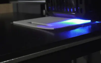 La stampa 3D in resina mostra un leggero warping, con la luce UV che illumina la superficie.