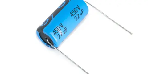 Un condensatore polarizzato blu con specifiche 450V 22µF, pronto per essere saldato.