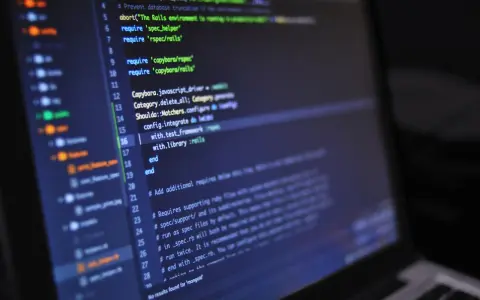 Codice sorgente su schermo scuro, con evidenziate righe di Ruby per il **front end**.