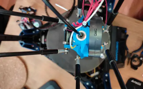 Parti di una Anycubic Kossel Linear Plus, con cavi rossi e bianchi che si snodano attorno all'estrusore blu.
