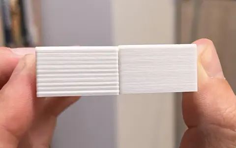 Due campioni stampati in 3D, uno con evidenti linee orizzontali dovute a z wobble, l'altro liscio.