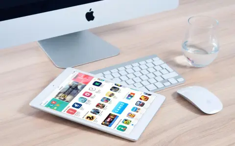 Un tablet mostra l'App Store, con icone di giochi e app, suggerendo come creare app. Un iMac, tastiera e mouse completano la scena.