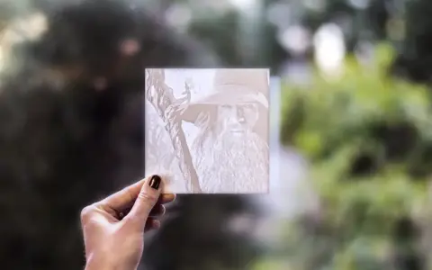 Litofanie 3D di Gandalf, tenuta in mano, con sfondo sfocato di alberi.