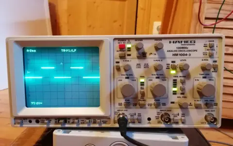 Un oscilloscopio Hamg HM 1004-3 mostra un segnale a onda quadra, probabilmente generato da un Arduino, con impostazioni di tempo e voltaggio visibili.