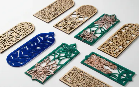 Segnalibri in legno e acrilico con intricati **progetti laser** floreali e geometrici.