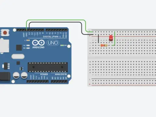 Un Arduino UNO collegato via USB a un computer, con un LED e un resistore connessi a una breadboard cos'è, per creare un circuito semplice.