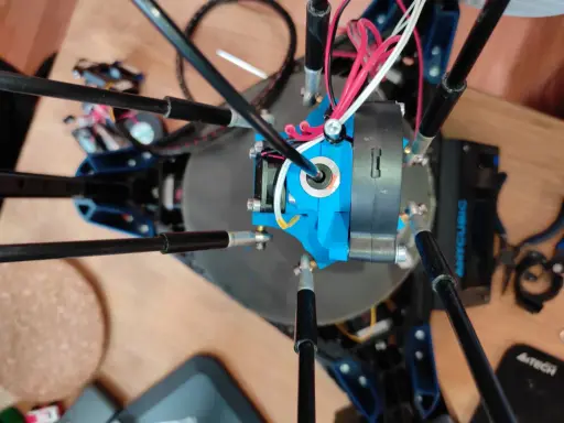 Parti di una Anycubic Kossel Linear Plus, con cavi rossi e bianchi che si snodano attorno all'estrusore blu.