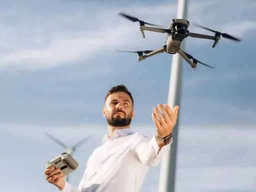 Uomo con telecomando e drone in volo, pronto per il suo patentino drone Lussemburgo.