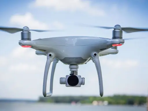 Un drone bianco con quattro eliche in movimento, pronto a catturare immagini aeree.