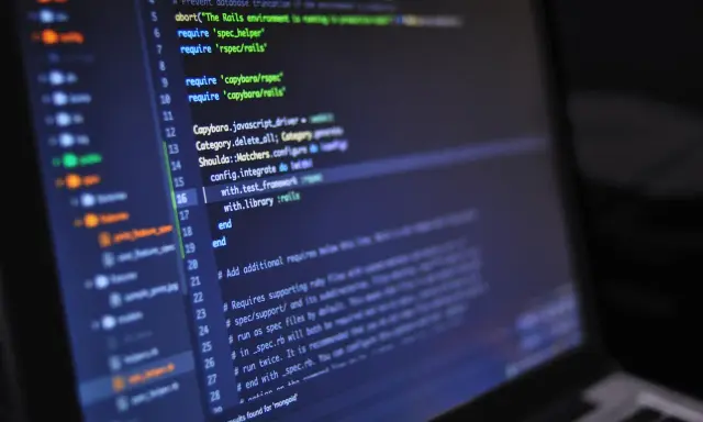 Codice sorgente su schermo scuro, con evidenziate righe di Ruby per il **front end**.
