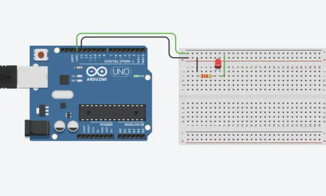 Un Arduino UNO collegato via USB a un computer, con un LED e un resistore connessi a una breadboard cos'è, per creare un circuito semplice.