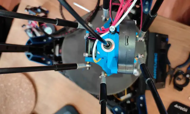 Parti di una Anycubic Kossel Linear Plus, con cavi rossi e bianchi che si snodano attorno all'estrusore blu.