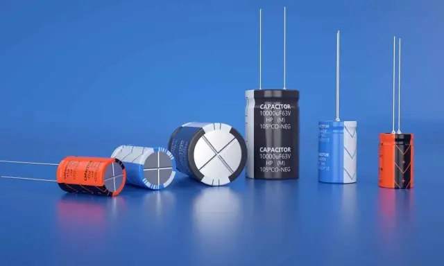 Varietà di condensatori di diverse dimensioni e colori, alcuni con etichette visibili, disposti su sfondo blu.