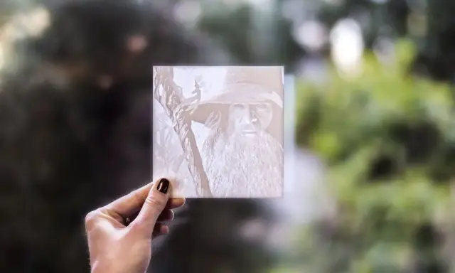 Litofanie 3D di Gandalf, tenuta in mano, con sfondo sfocato di alberi.