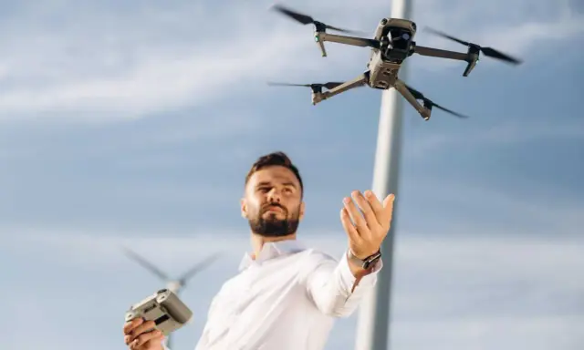 Uomo con telecomando e drone in volo, pronto per il suo patentino drone Lussemburgo.