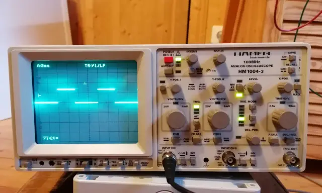 Un oscilloscopio Hamg HM 1004-3 mostra un segnale a onda quadra, probabilmente generato da un Arduino, con impostazioni di tempo e voltaggio visibili.