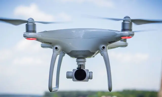 Un drone bianco con quattro eliche in movimento, pronto a catturare immagini aeree.