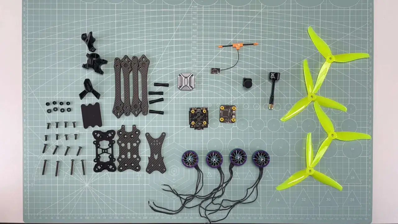 Componenti per costruire drone FPV: frame in carbonio, motori, eliche, ESC, flight controller, camera e antenna.
