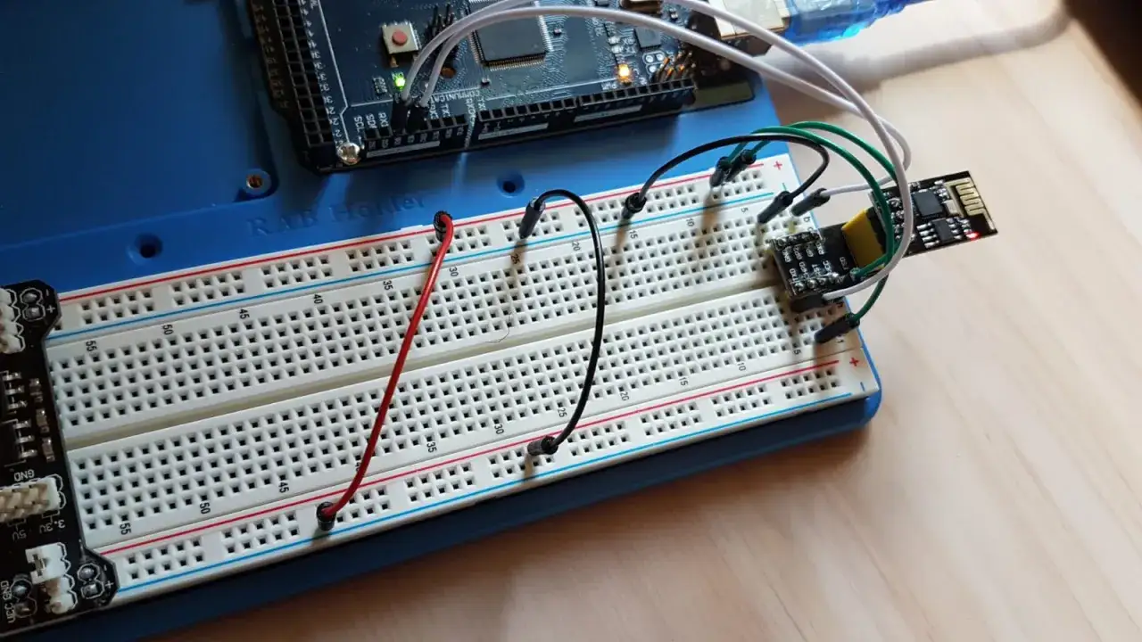 Un modulo ESP8266 collegato a una breadboard, con cavi che partono da un Arduino. Il GND &egrave; ben visibile.