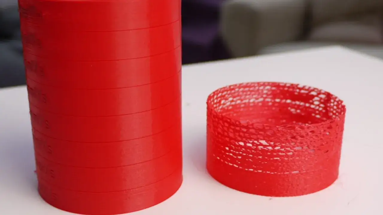 Due oggetti rossi stampati in 3D: uno solido e uno con evidenti problemi di under extrusion, che mostra vuoti e filamenti.