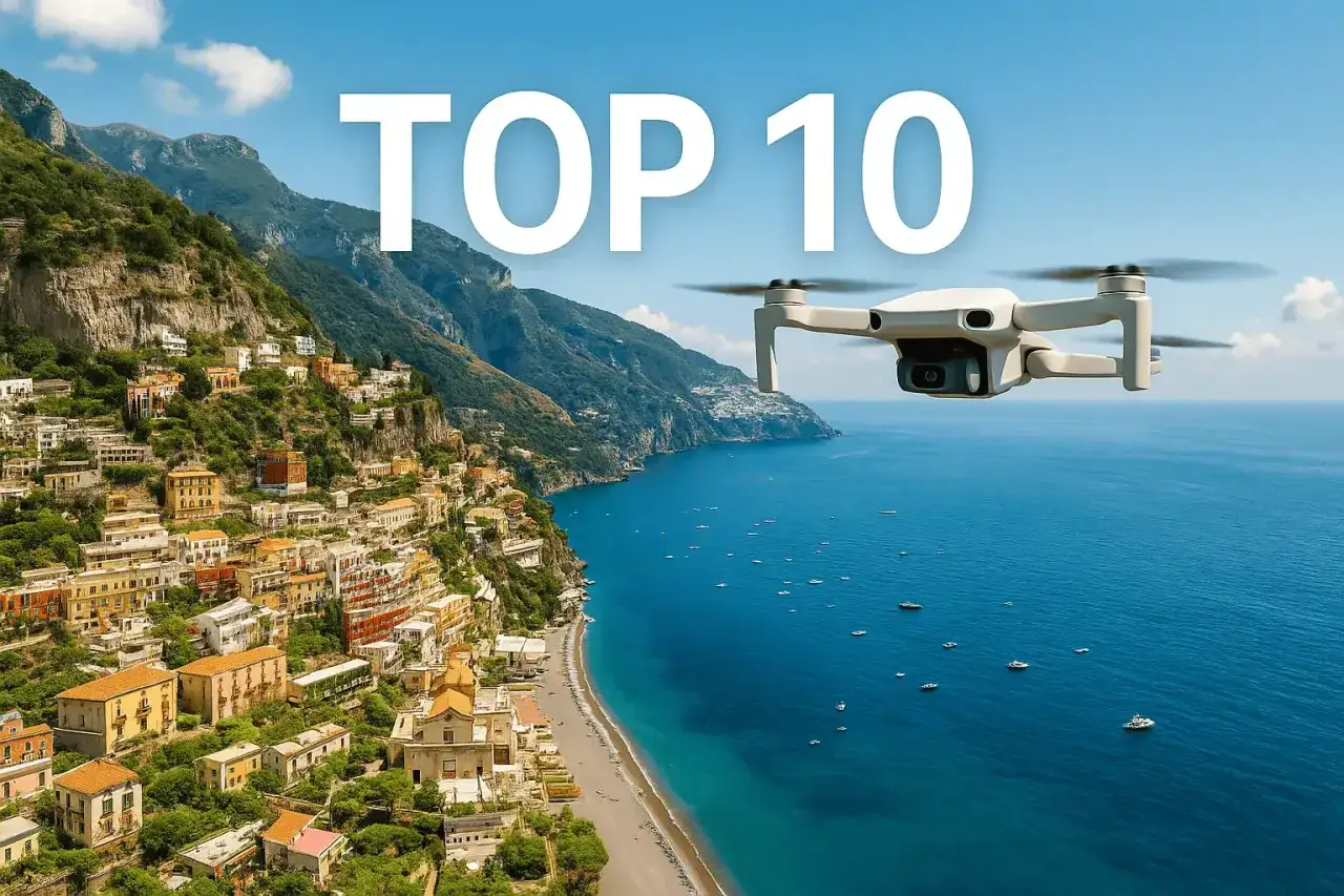 Un drone cattura immagini mozzafiato della costa italiana, con case colorate aggrappate alle scogliere e il mare blu intenso.