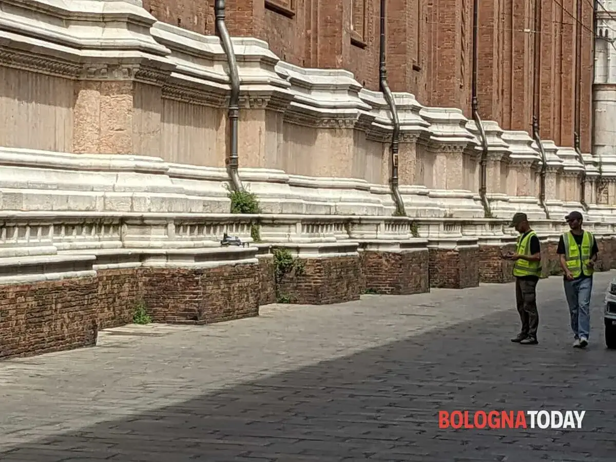 Due uomini con giubbotti ad alta visibilità controllano un drone, forse in attesa dell'autorizzazione volo drone comune per riprese aeree.